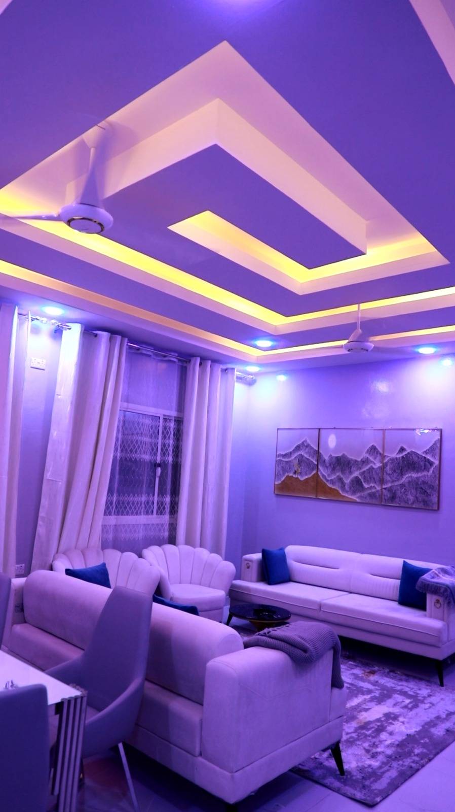 Finished living room with layered gypsum ceiling and cove lighting