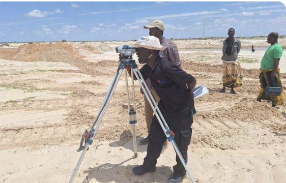 Nasteex surveyor taking levels with a dumpy level on an open site