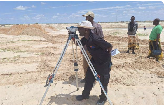 Nasteex surveyor taking levels with a dumpy level on an open site