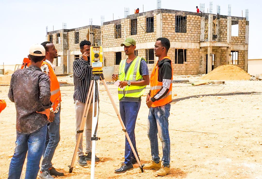 Survey team operating a total station on an active site