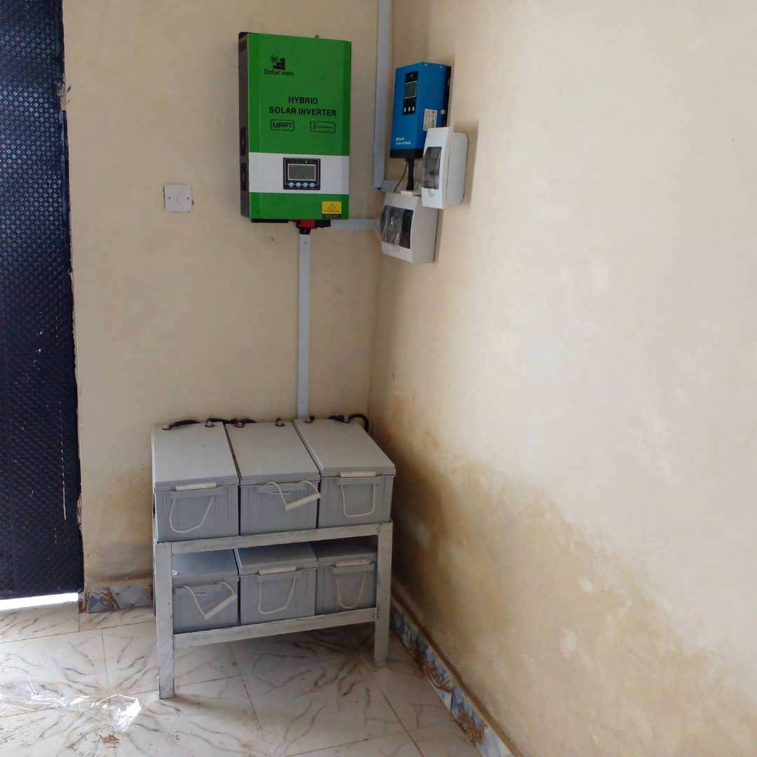 Wall-mounted solar inverter above a rack of batteries