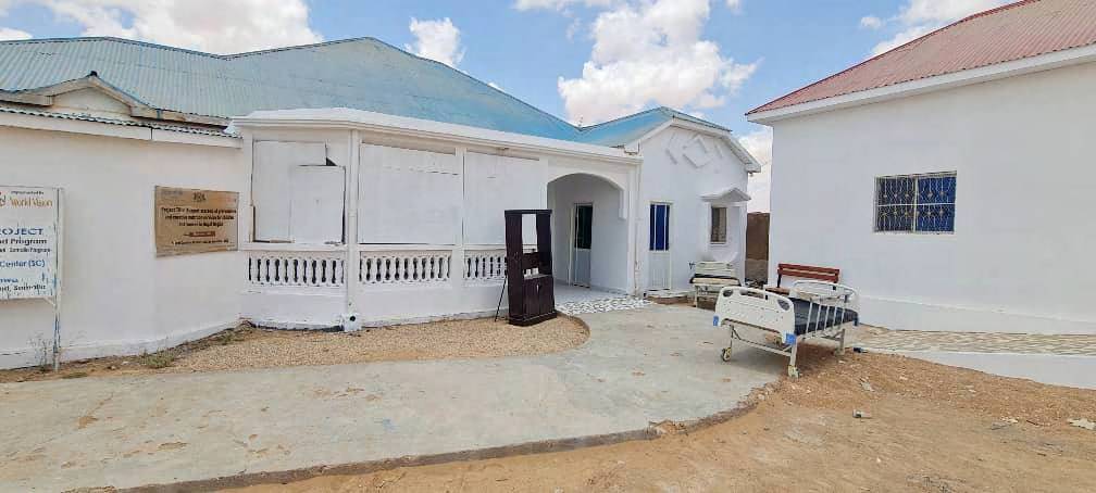 Completed white public building with a paved forecourt