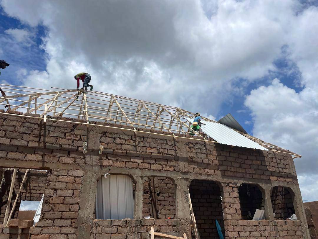 Roofing sheets being fixed to timber trusses